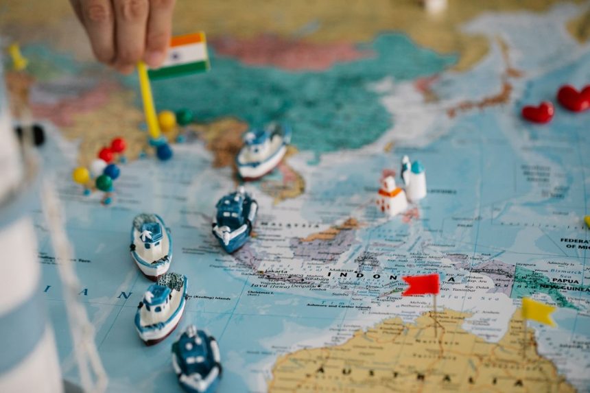 Mapa-múndi com pequenos navios e bandeiras indicando rotas e pontos do comércio internacional